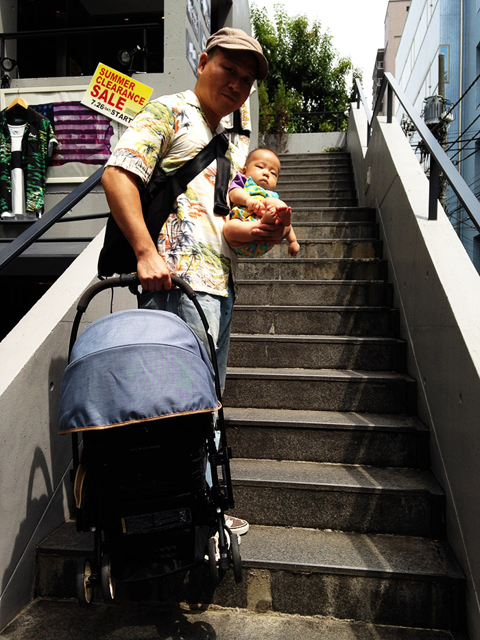階段にて。赤ちゃんとベビーカーを担いであがる。