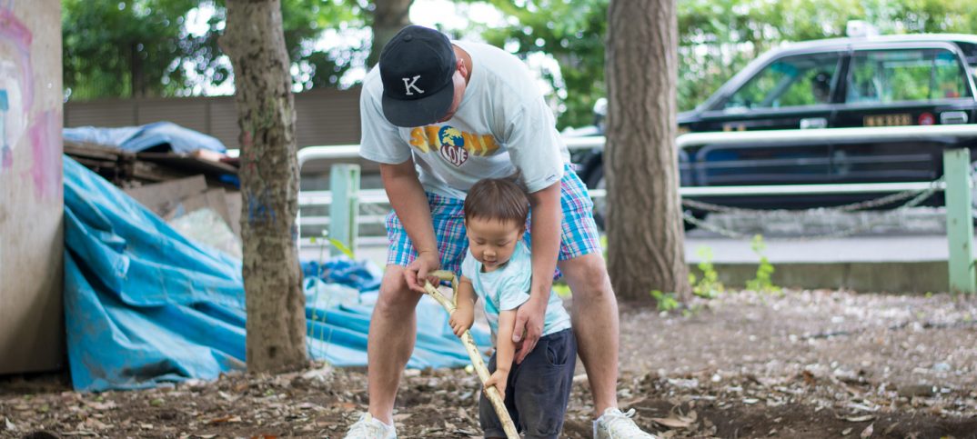 息子とショベルで土を掘る父親