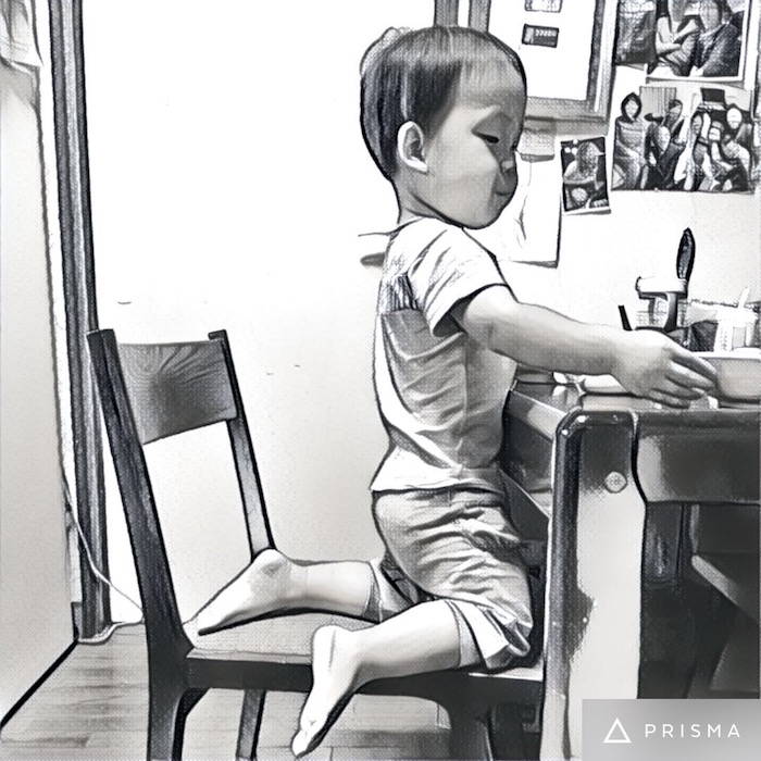 大人のダイニングチェアに座って食べる2歳の息子