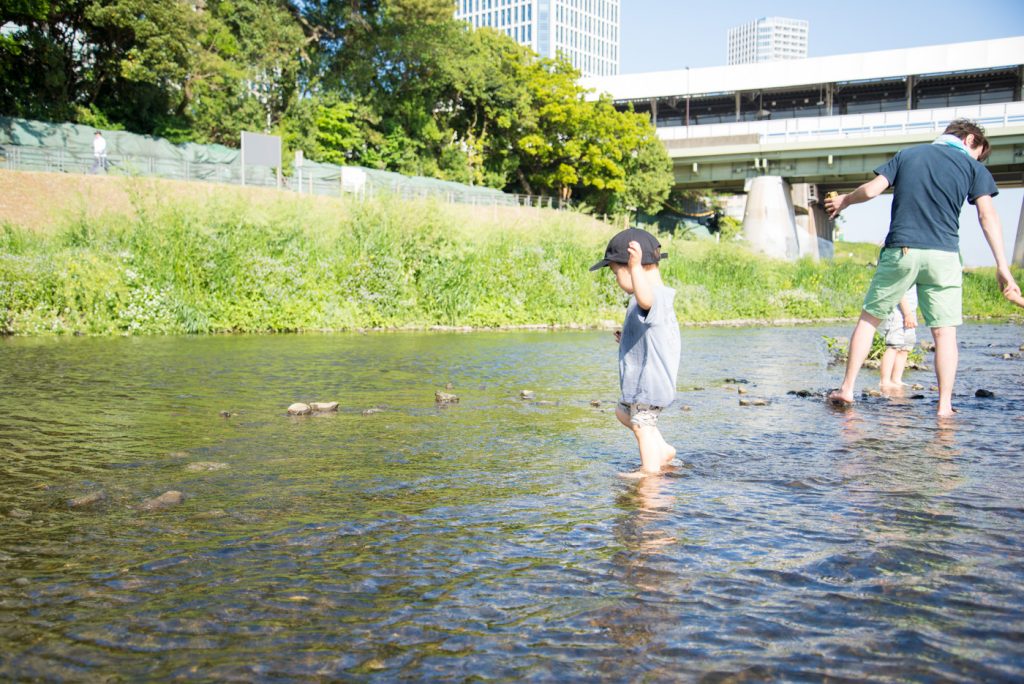 多摩川で水遊びする子供