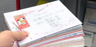 手紙入りの年賀状を、封書（封筒）でポストに投函するところ