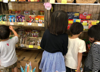 駄菓子屋さんで、お菓子を選ぶ子どもたち