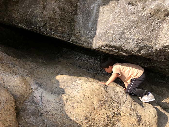 岩の隙間・洞窟を探検する子ども