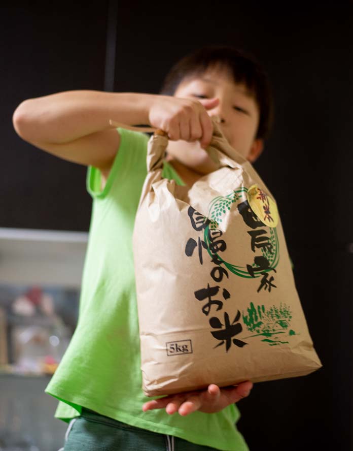 米袋を担ぐ7歳の息子
