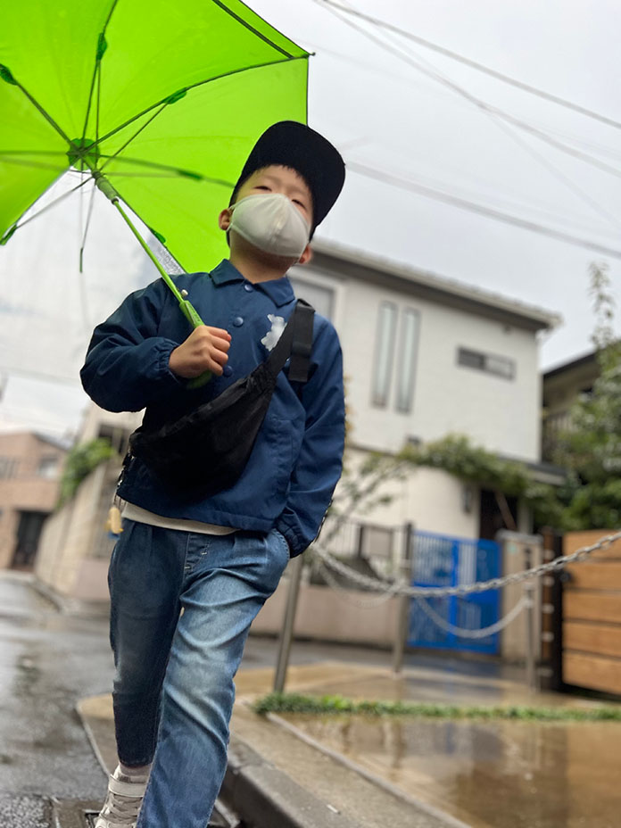 傘をさして歩く、7歳の息子