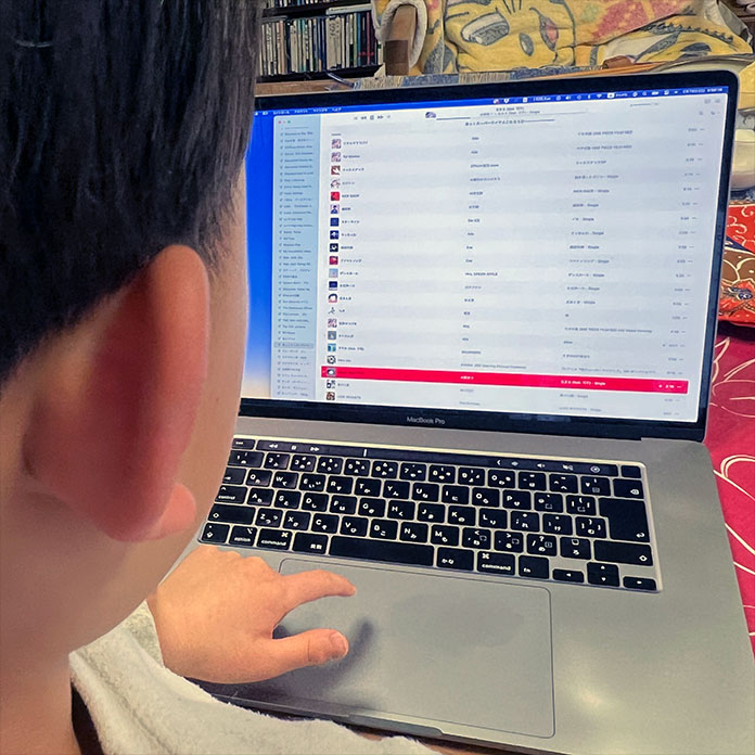 MacBookで音楽を聴く子ども