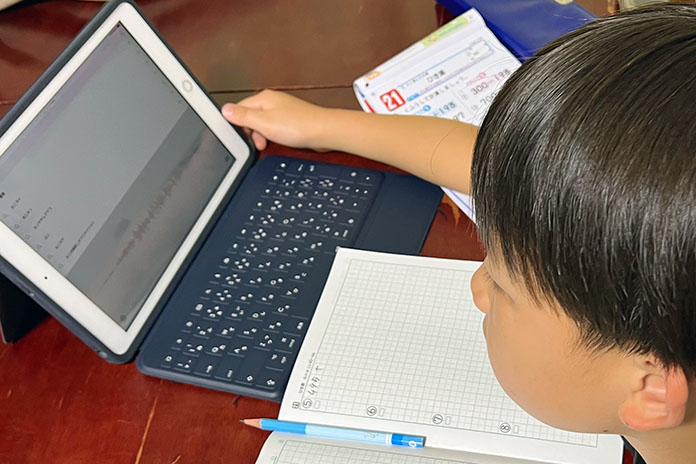 iPadをつかって宿題をしている小学生男児