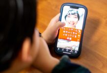 スマートフォンでYouTubeショートを見ている小学生男児