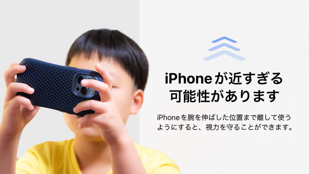 スマホを顔の近くで使っている子どもと「iPhoneが近すぎる可能性があります」の警告