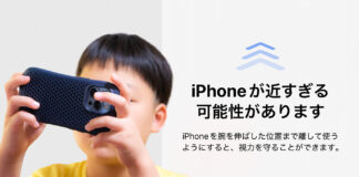 スマホを顔の近くで使っている子どもと「iPhoneが近すぎる可能性があります」の警告