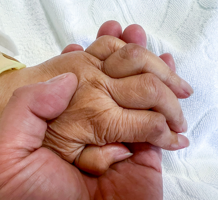 52歳の息子が、75歳の母の手をそっととり手を繋いでいる様子