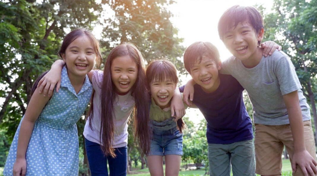 小学生5人組が笑顔で肩を組んでいる