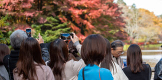 軽井沢の雲場池で紅葉を撮影する観光客